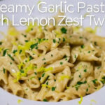 Steaming bowl of creamy garlic pasta with lemon zest, topped with fresh parsley and Parmesan